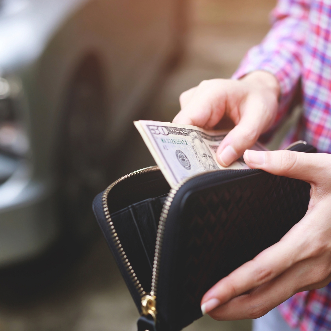 person pulling money out of wallet